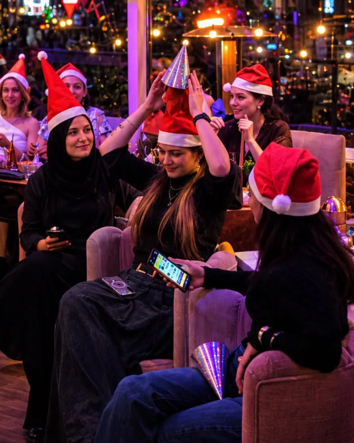 Gasten met kerstmutsen samen in de lounge van Broox Rotterdam tijdens een kerstavond met kerstspelshow